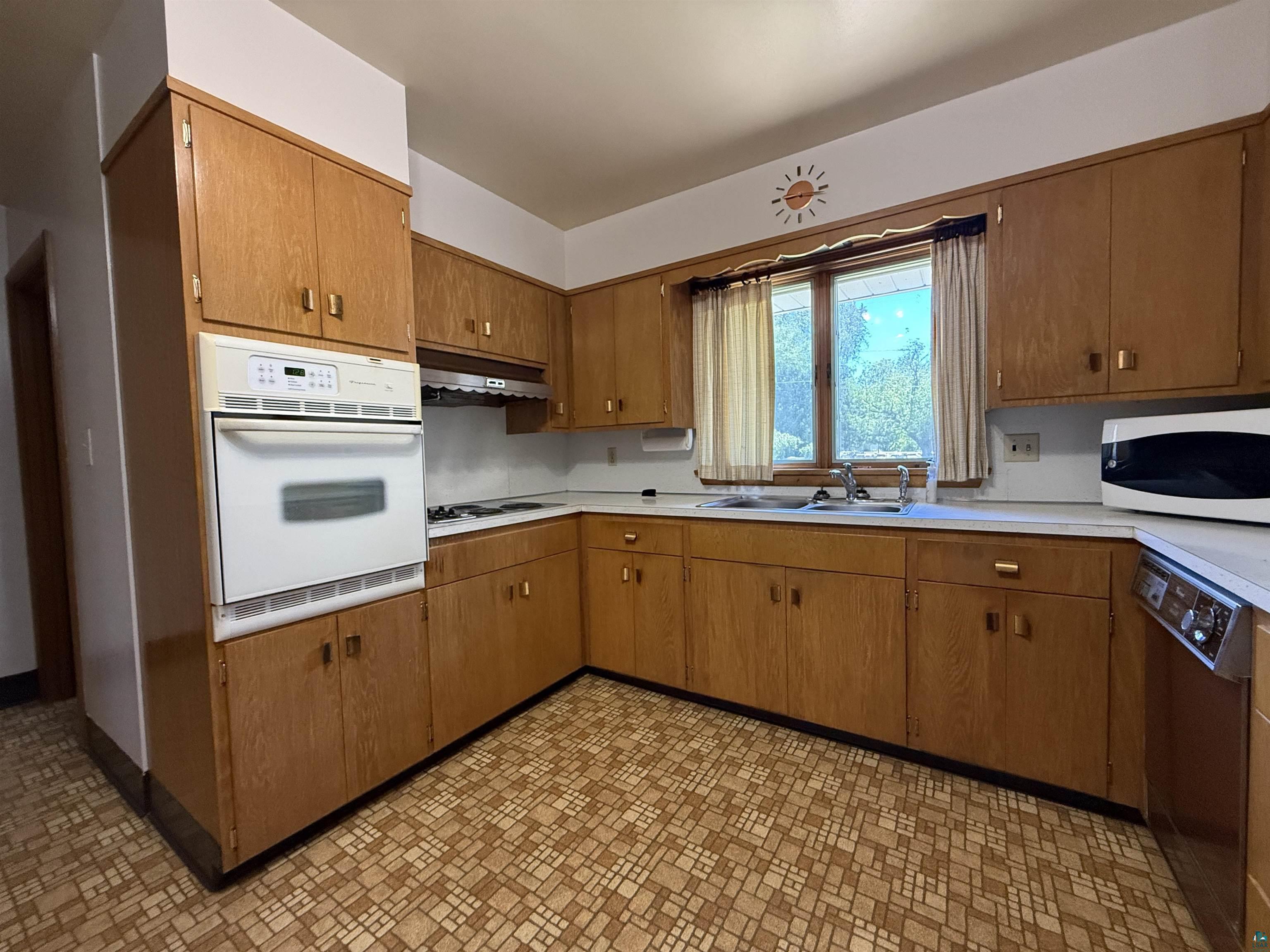 607 3rd Street Northeast Chisholm, MN 55719 - Photo 10 of 32 Kitchen featuring wood-finish cabinetry, built-in oven, and a gas cooktop