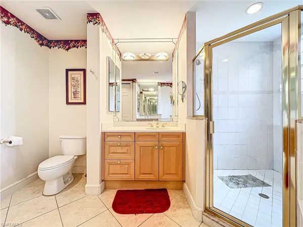a bathroom with a granite countertop sink mirror vanity and toilet