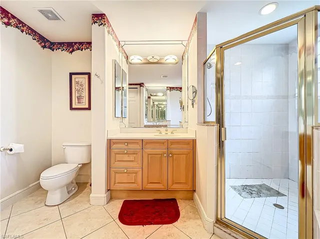 a bathroom with a granite countertop sink mirror vanity and toilet