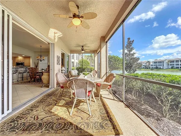 a dining room with wooden floor a chandelier with a rug table and chairs