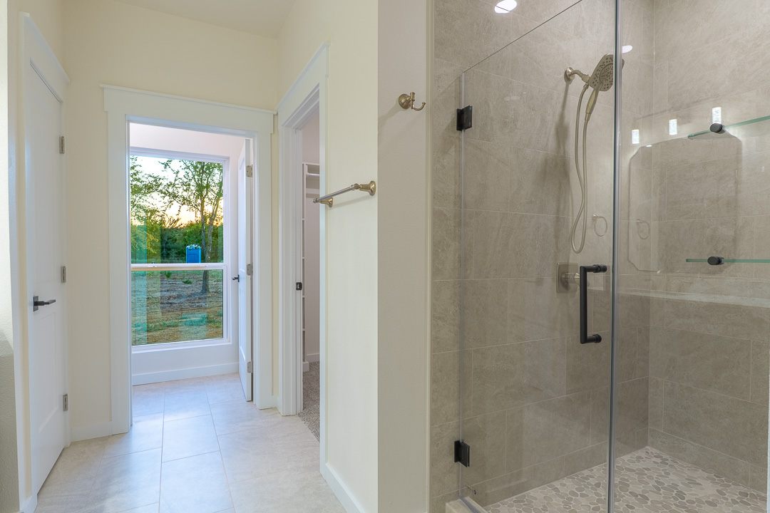 205 Blessings Way Colbert, OK 74733 - Photo 17 of 24 Glass-enclosed shower with matte black hardware, textured tile surround, and built-in shower shelving