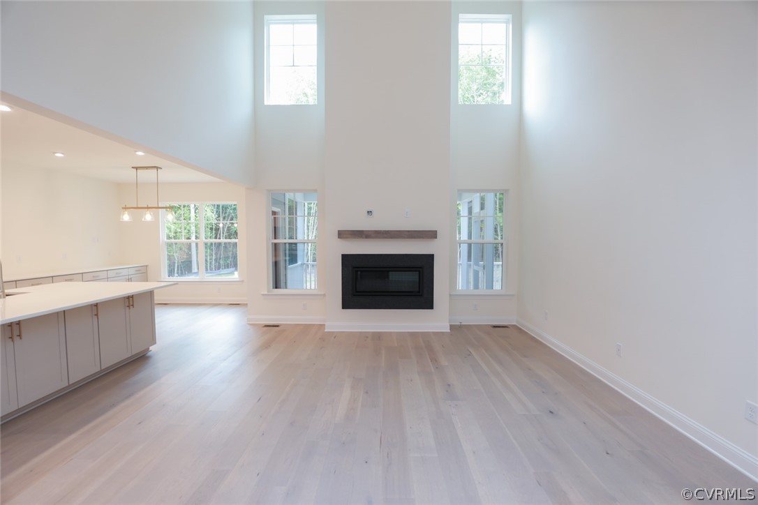 3404 Nickel Spring Sandy Hook, VA 23153 - Photo 7 of 45 an empty room with wooden floor a fireplace and windows