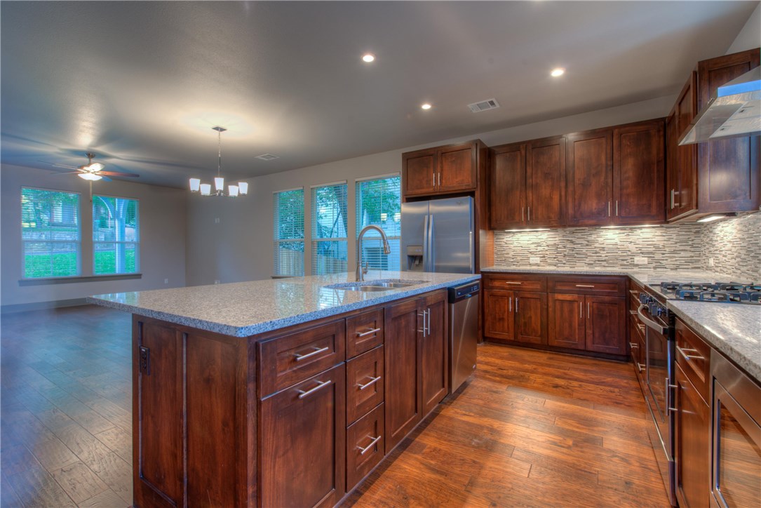 3110 Grandview Street Austin, TX 78705 - Photo 4 of 30 a kitchen with kitchen island granite countertop wooden cabinets a counter top space and stainless steel appliances