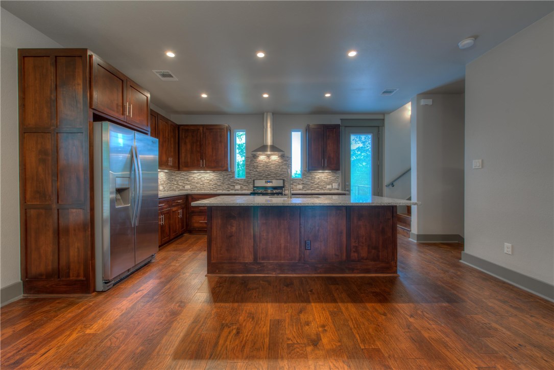 3110 Grandview Street Austin, TX 78705 - Photo 5 of 30 a kitchen with stainless steel appliances granite countertop wooden floors wooden cabinets and entryway