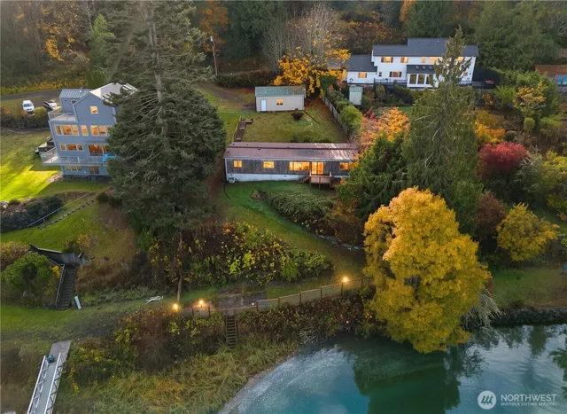 an aerial view of a house with a yard and lake view