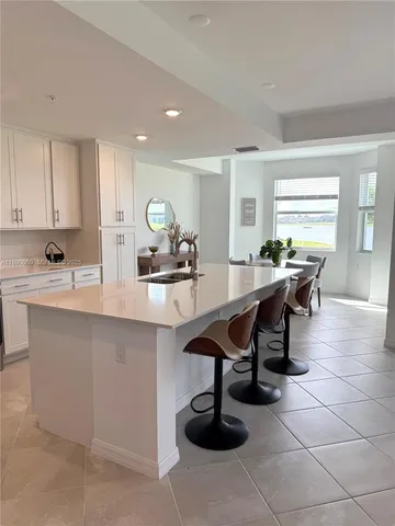 a kitchen with a sink a counter and chairs