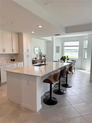 a kitchen with a sink a counter and chairs