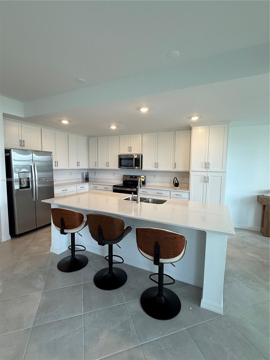 5555 Double Eager Circle, Unit 3917 Immokalee, FL 34142 - Photo 3 of 16 a kitchen with refrigerator and chairs
