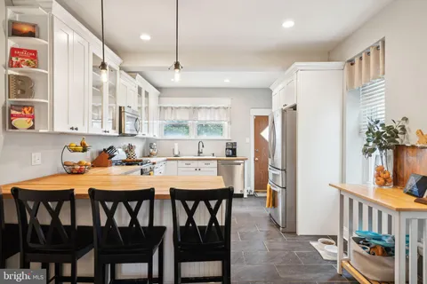 a kitchen with a table chairs refrigerator and microwave