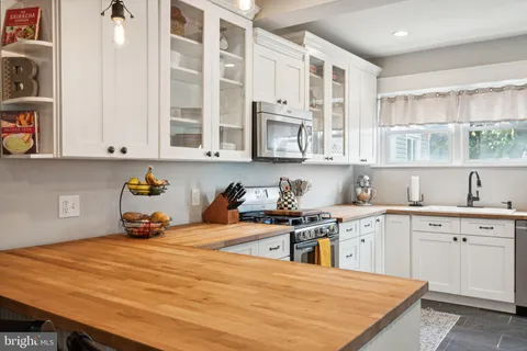 a kitchen with stainless steel appliances granite countertop a stove a sink and a white cabinets