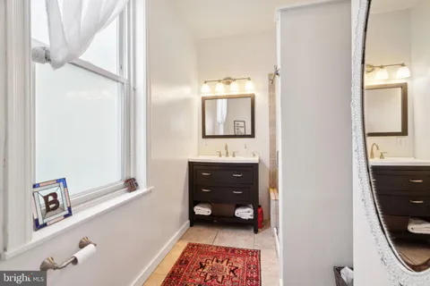 a bathroom with a sink a mirror and a window