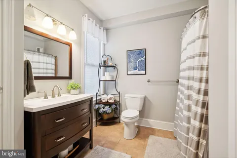 a bathroom with a sink toilet a mirror and shower curtain