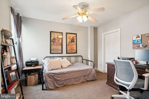 a bedroom with a bed a couch and a window