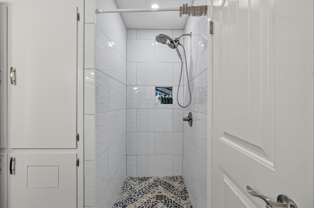 47 Bounty Road East Benbrook, TX 76132 - Photo 27 of 39 Walk-in shower featuring patterned mosaic tile flooring, a built-in shower niche, and a multi-function showerhead