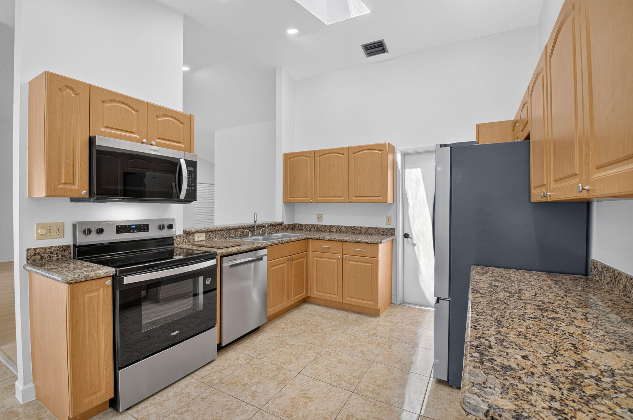 21070 Woodspring Avenue Boca Raton, FL 33428 - Photo 8 of 30 a kitchen with stainless steel appliances granite countertop a stove top oven microwave and refrigerator