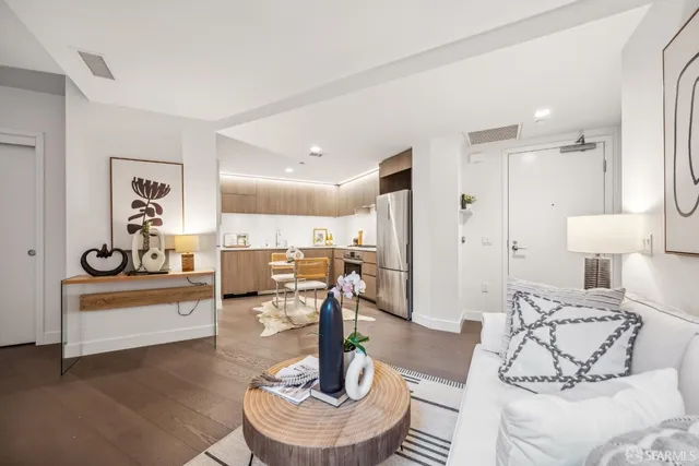 a kitchen with a refrigerator a stove and a sink with wooden floor