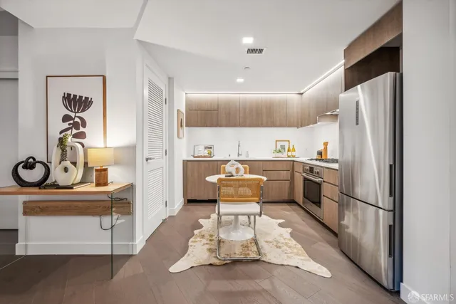 a kitchen with stainless steel appliances granite countertop a refrigerator and a dining table