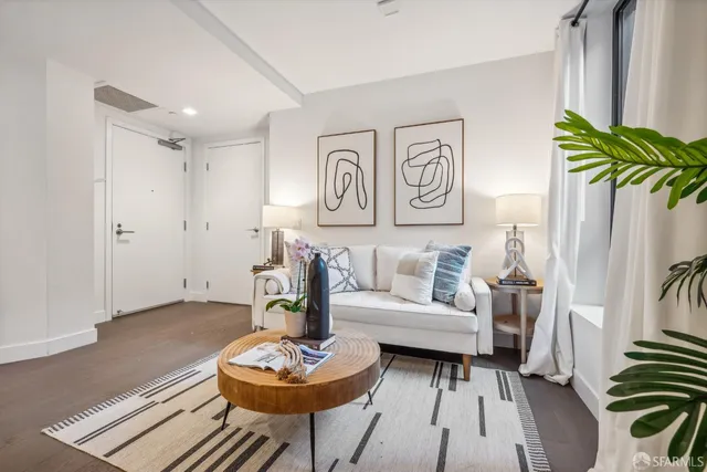 a living room with furniture and a wooden floor