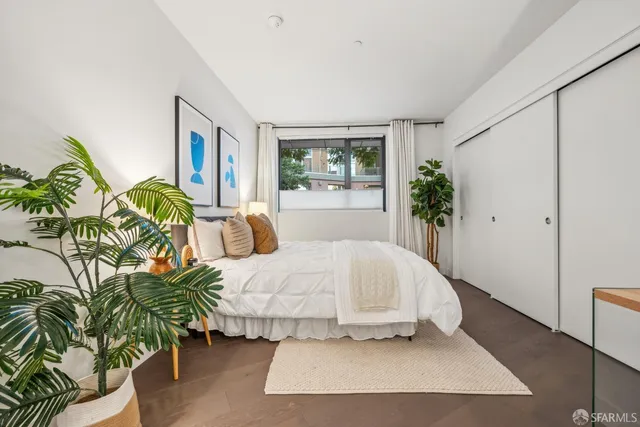 a bedroom with a bed and a potted plant