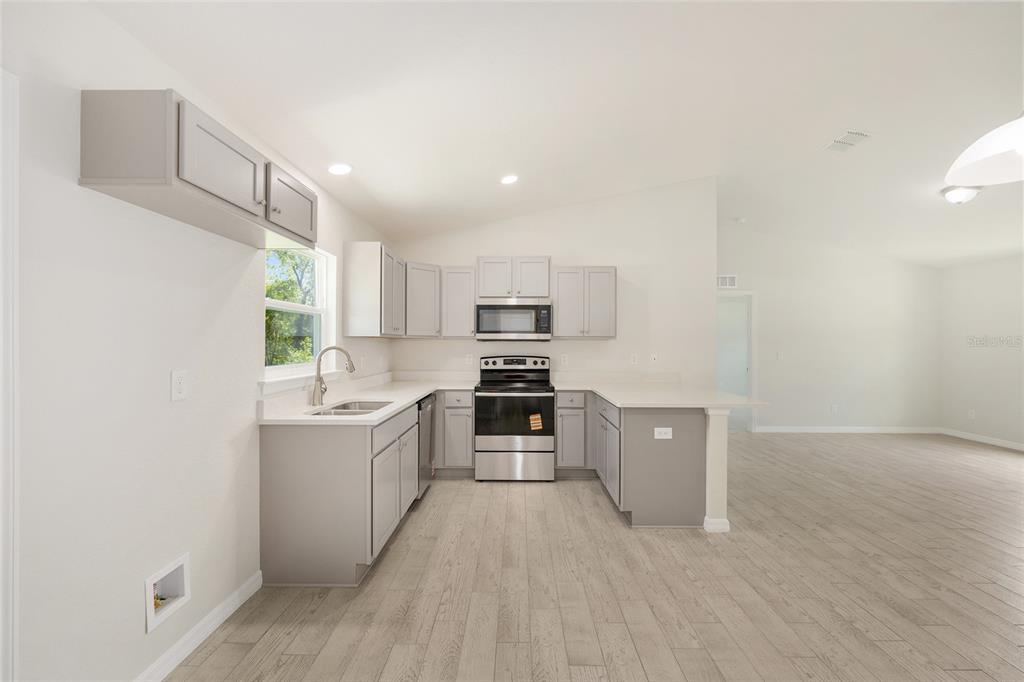 29 Olive Cir Loop Ocala, FL 34472 - Photo 20 of 49 a large kitchen with cabinets wooden floor and stainless steel appliances