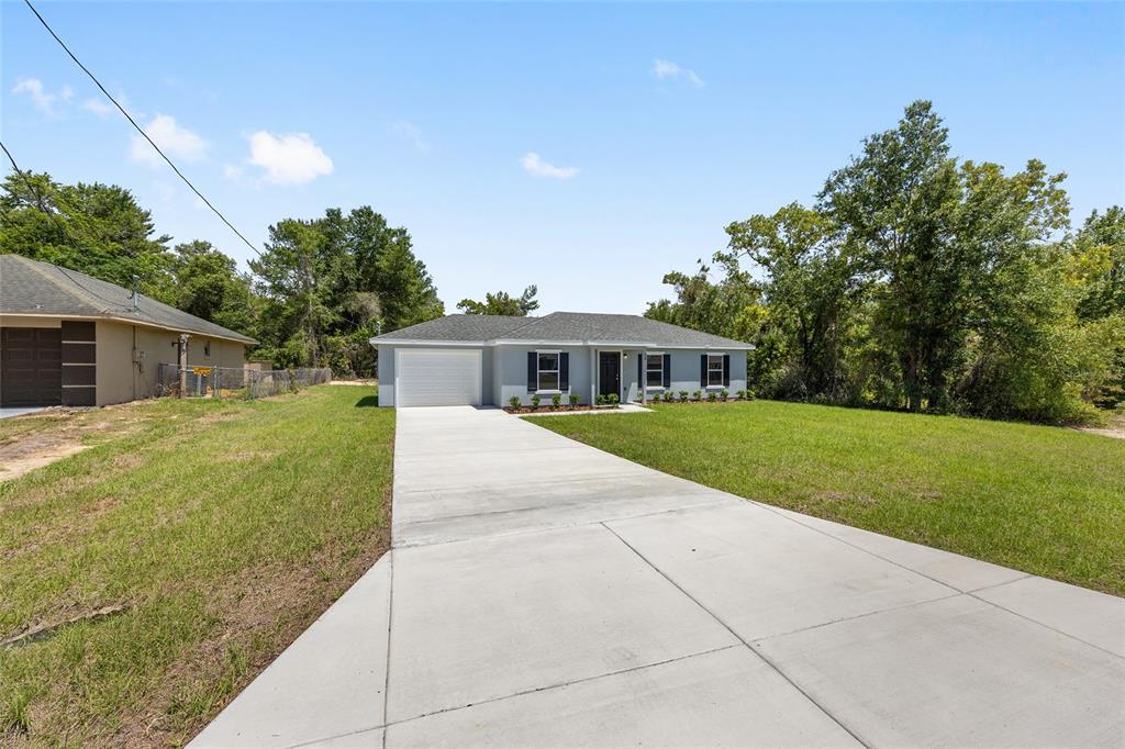 29 Olive Cir Loop Ocala, FL 34472 - Photo 2 of 49 a front view of house with yard and green space