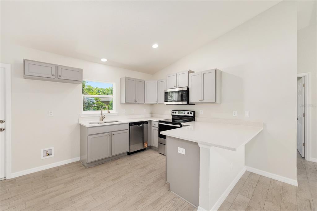 29 Olive Cir Loop Ocala, FL 34472 - Photo 21 of 49 a kitchen with a sink a stove a refrigerator a center island and a window