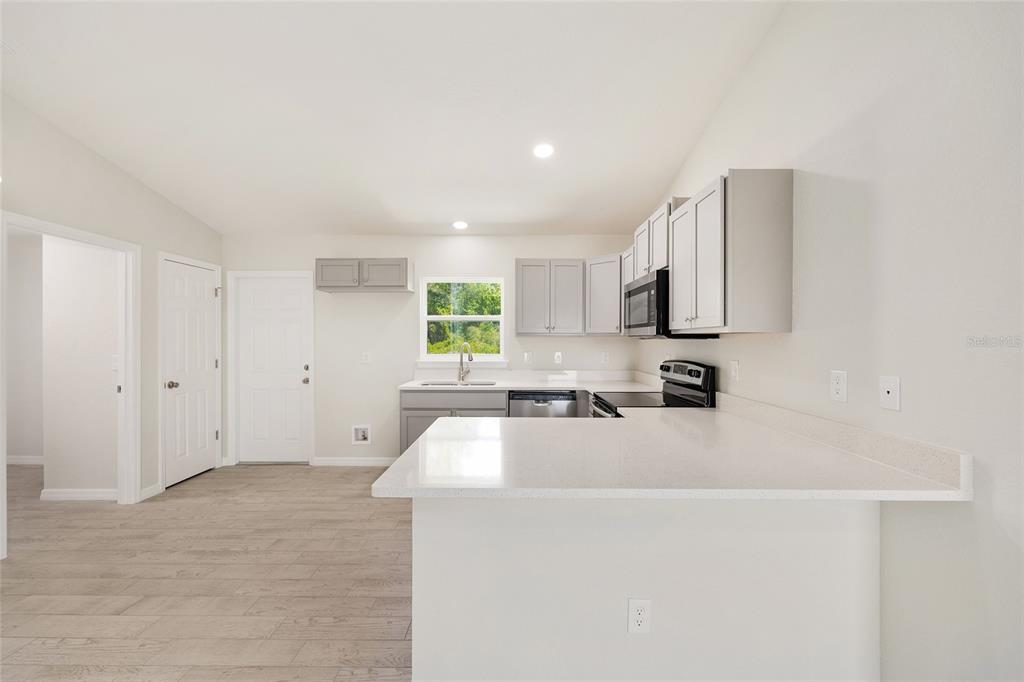 29 Olive Cir Loop Ocala, FL 34472 - Photo 22 of 49 a large white kitchen with cabinets appliances a sink and a window