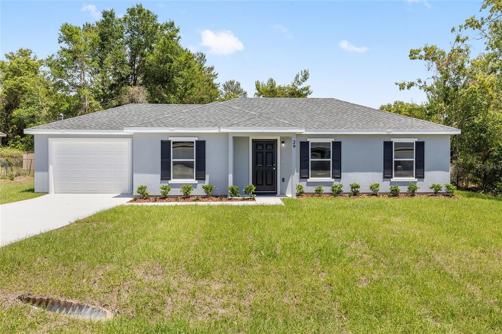 29 Olive Cir Loop Ocala, FL 34472 - Photo 4 of 49 a front view of house with yard and green space
