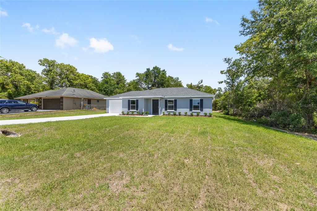 29 Olive Cir Loop Ocala, FL 34472 - Photo 5 of 49 a front view of house with yard and green space