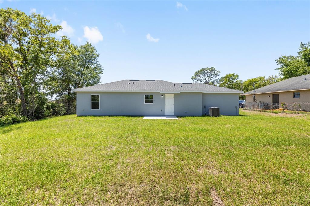 29 Olive Cir Loop Ocala, FL 34472 - Photo 9 of 49 a front view of house with yard and trees