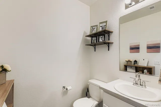 a bathroom with a sink a toilet and mirror