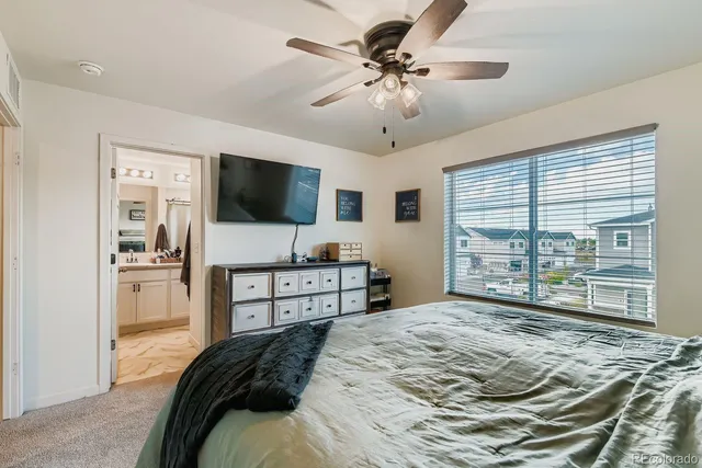 a bedroom with a bed and a ceiling fan