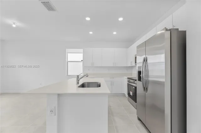 a kitchen with refrigerator and car parked