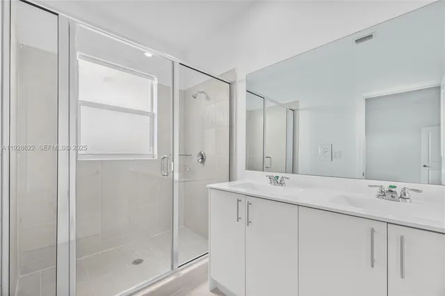 a bathroom with a shower sink and mirror