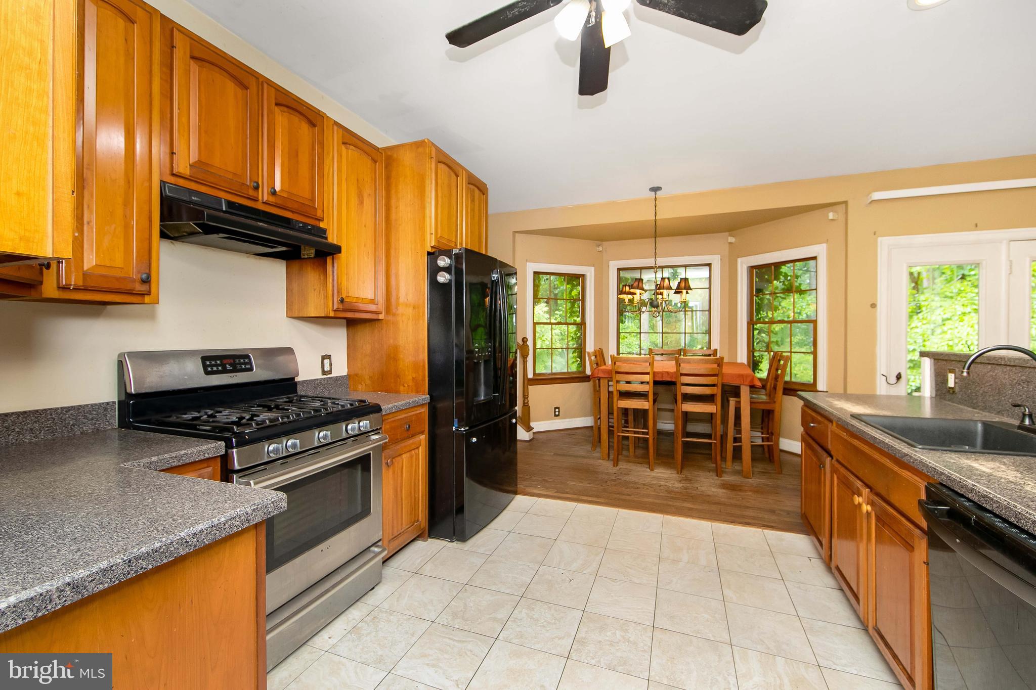 51 E Road Gibbsboro, NJ 08026 - Photo 24 of 42 a kitchen with stainless steel appliances granite countertop a stove a refrigerator a sink a dining table and chairs with wooden floor