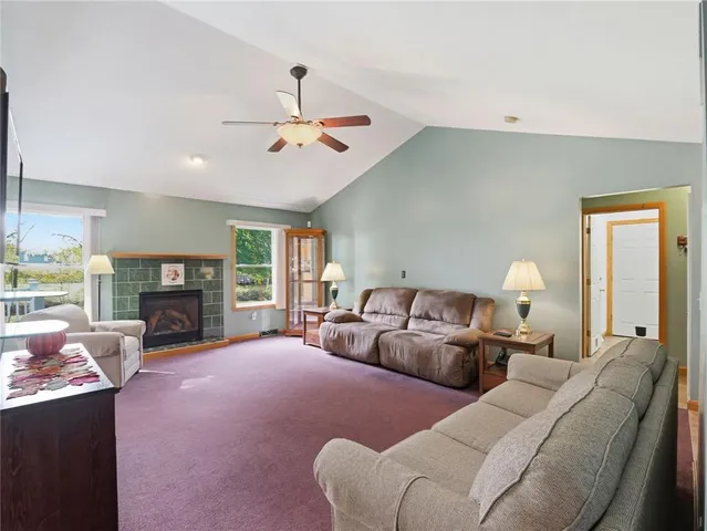 a living room with furniture large window and fireplace