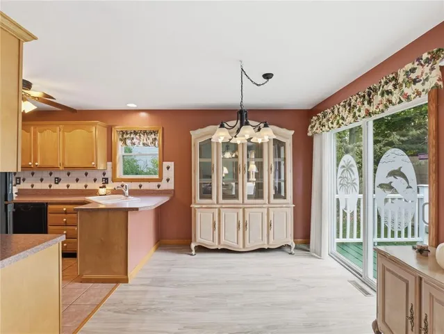 a view of a kitchen with kitchen island granite countertop wooden floor and stainless steel appliances