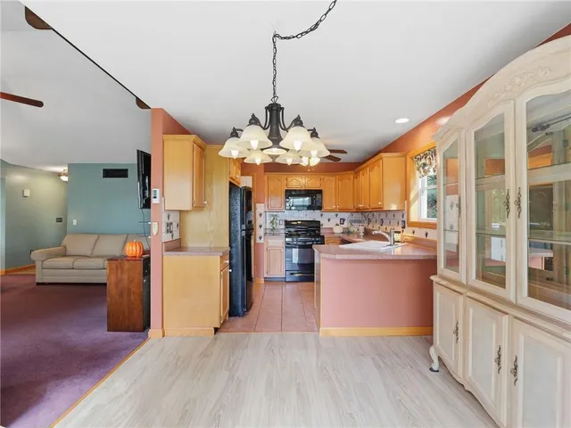 a kitchen with stainless steel appliances granite countertop a refrigerator a oven and a stove with wooden floor