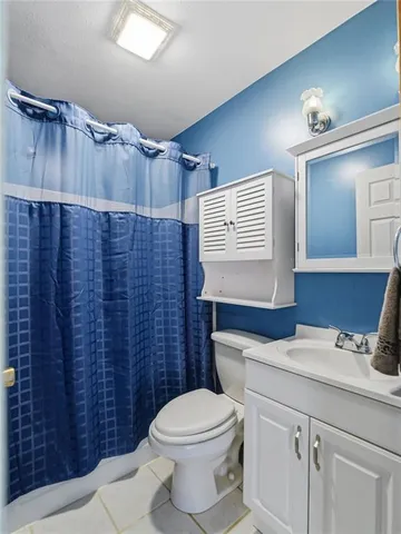 a bathroom with a toilet a sink and mirror