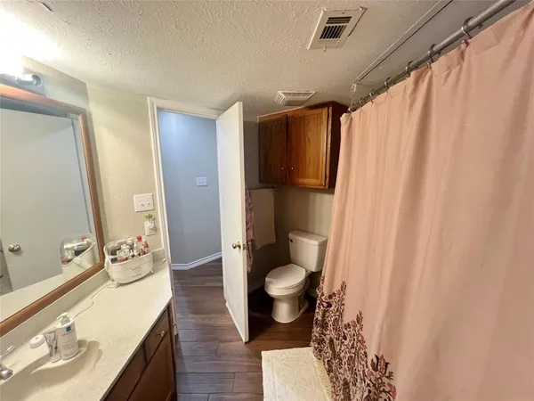 a bathroom with a granite countertop sink toilet and shower