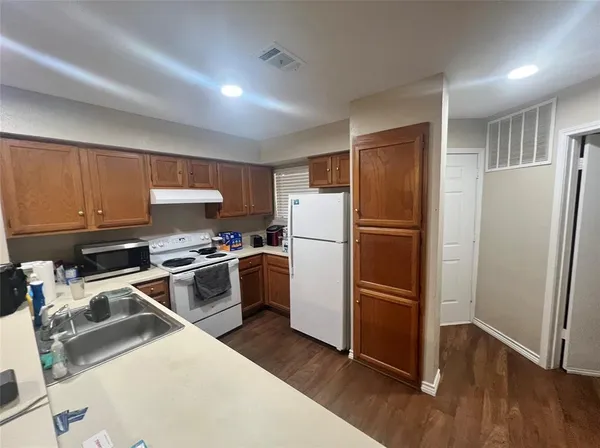a kitchen with wooden cabinets and stainless steel appliances