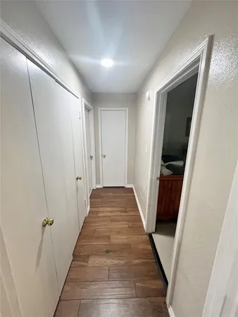 a view of hallway with stairs and wooden floor