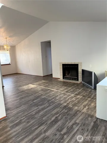a view of empty room with wooden floor and fireplace
