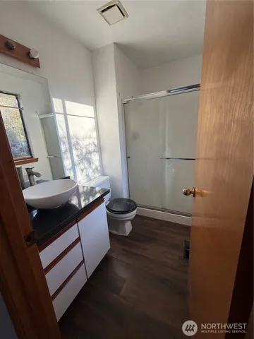 a living room with a couch and a potted plant on the wall