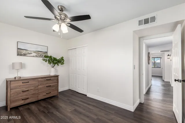 a view of a hallway with wooden floor and cabinet