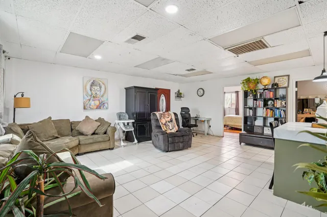 a living room with furniture a flat screen tv and kitchen view