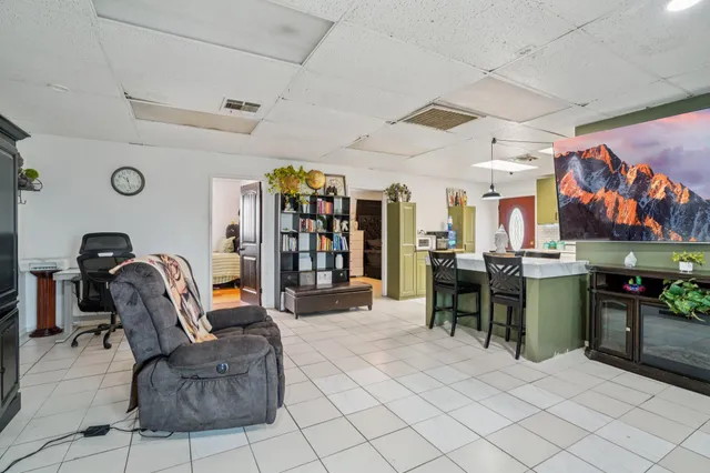 a living room with furniture a chandelier and a flat screen tv