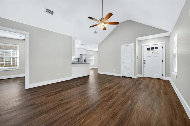 a view of a livingroom with wooden floor and a ceiling fan