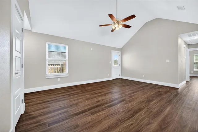 an empty room with wooden floor a ceiling fan and a window