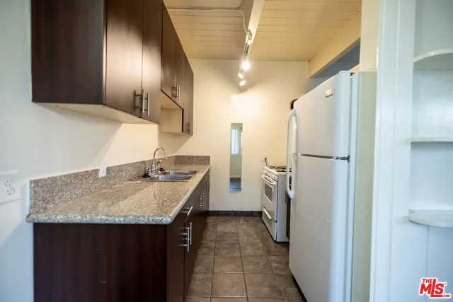 a kitchen with a sink refrigerator and cabinets